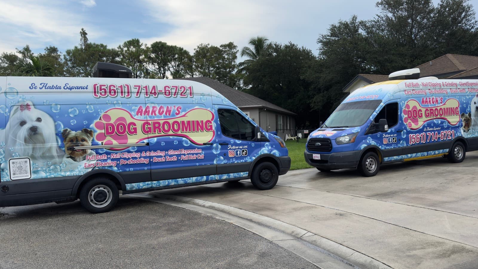 Two Aaron's Dog Grooming vans side by side
